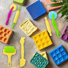 A collection of colorful play dough tools including rollers, spatulas, and shaping tools for creative play.