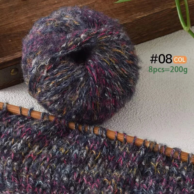 A ball of dark gray and purple alpaca blend yarn is shown next to a knitted fabric swatch.