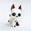 A white and brown pet figurine resembling a dachshund kitten with large blue eyes.