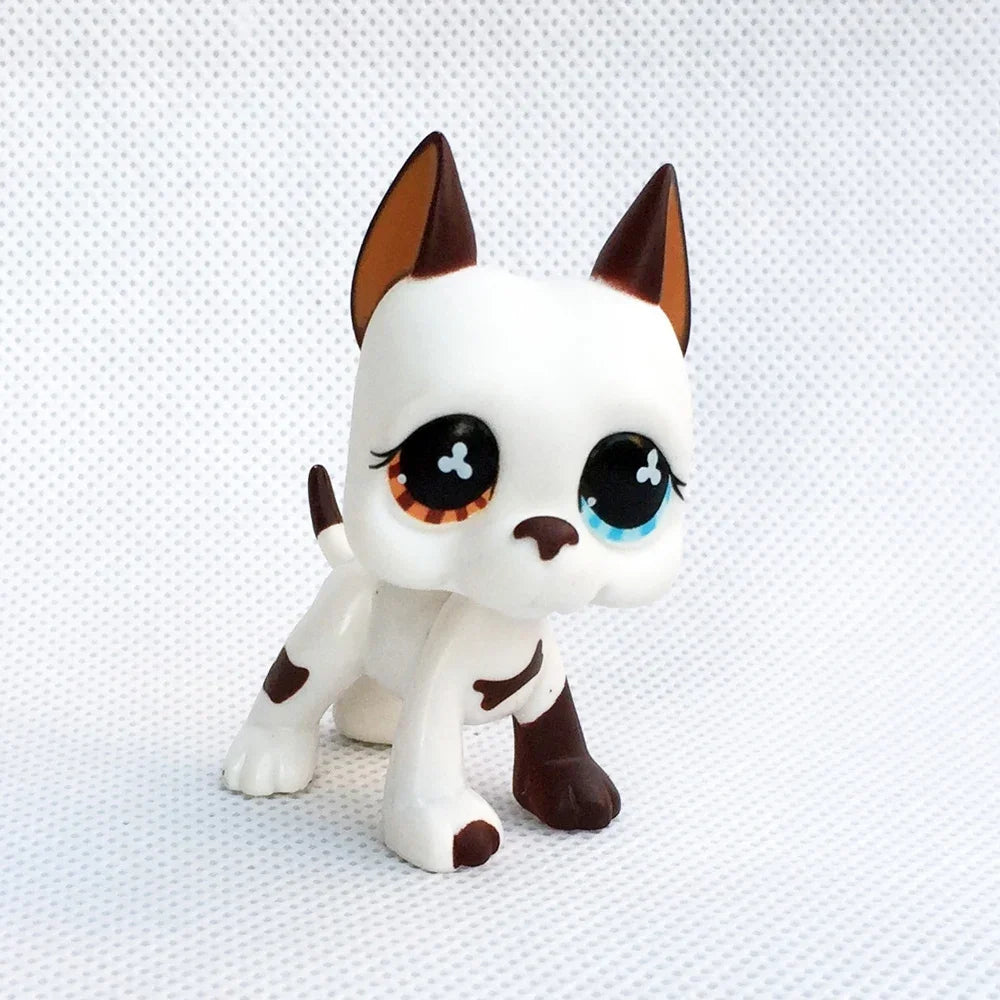 A white and brown pet figurine resembling a dachshund kitten with large blue eyes.
