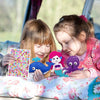 Two young girls are looking at and interacting with a felt sewing kit featuring woodland animals.