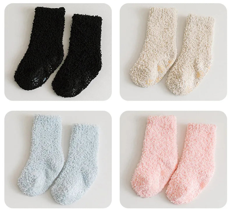 Three pairs of baby anti-slip fleece socks in black, cream, and pink.