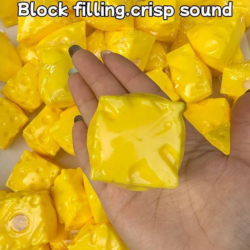 A hand is squeezing a bright yellow, squishy cheese stress ball for ASMR or fidgeting.