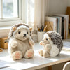 A soft, light-colored hedgehog plush toy sitting on a white table next to a white window.