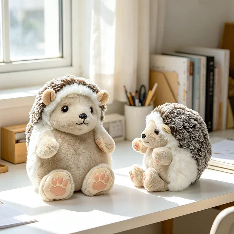 A soft, light-colored hedgehog plush toy sitting on a white table next to a white window.