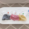 A flat lay of a floral print girls' summer t-shirt and shorts set in various patterns like plaid, gingham, and yellow stripes