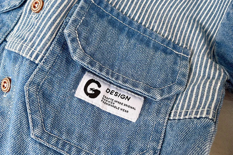 Close-up of a light blue striped denim jacket showing a sewn-in tag with a black G design.
