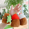 A hand holds three adorable capybara plush keychain charms in shades of brown, green, and white.