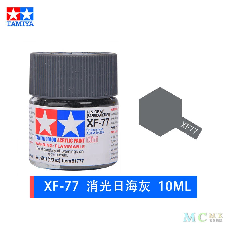 A glass jar of XF-77 fluorescent yellow acrylic paint, labeled for model kits and miniatures.