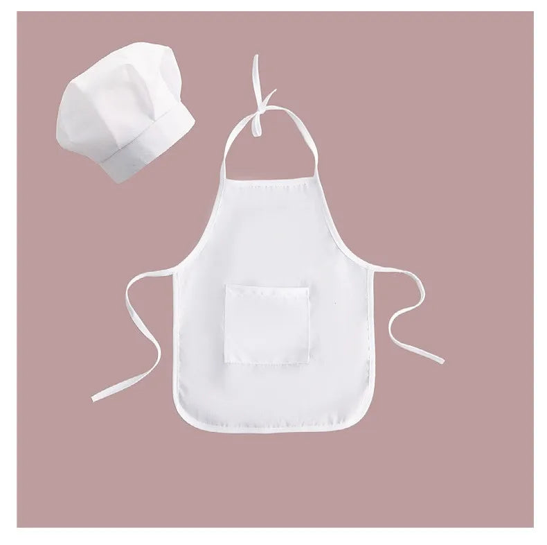 White kids chef apron and hat set for pretend play displayed on a pink background.