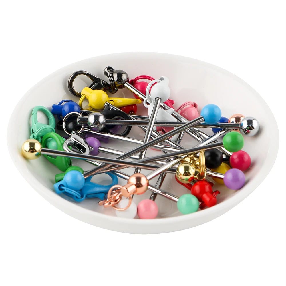 A collection of metal keychain bars with lobster clasps in various colors and finishes, arranged in a white bowl.