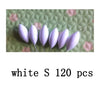 A close-up photo of white oval fishing floats with bobber beads arranged on a green surface.