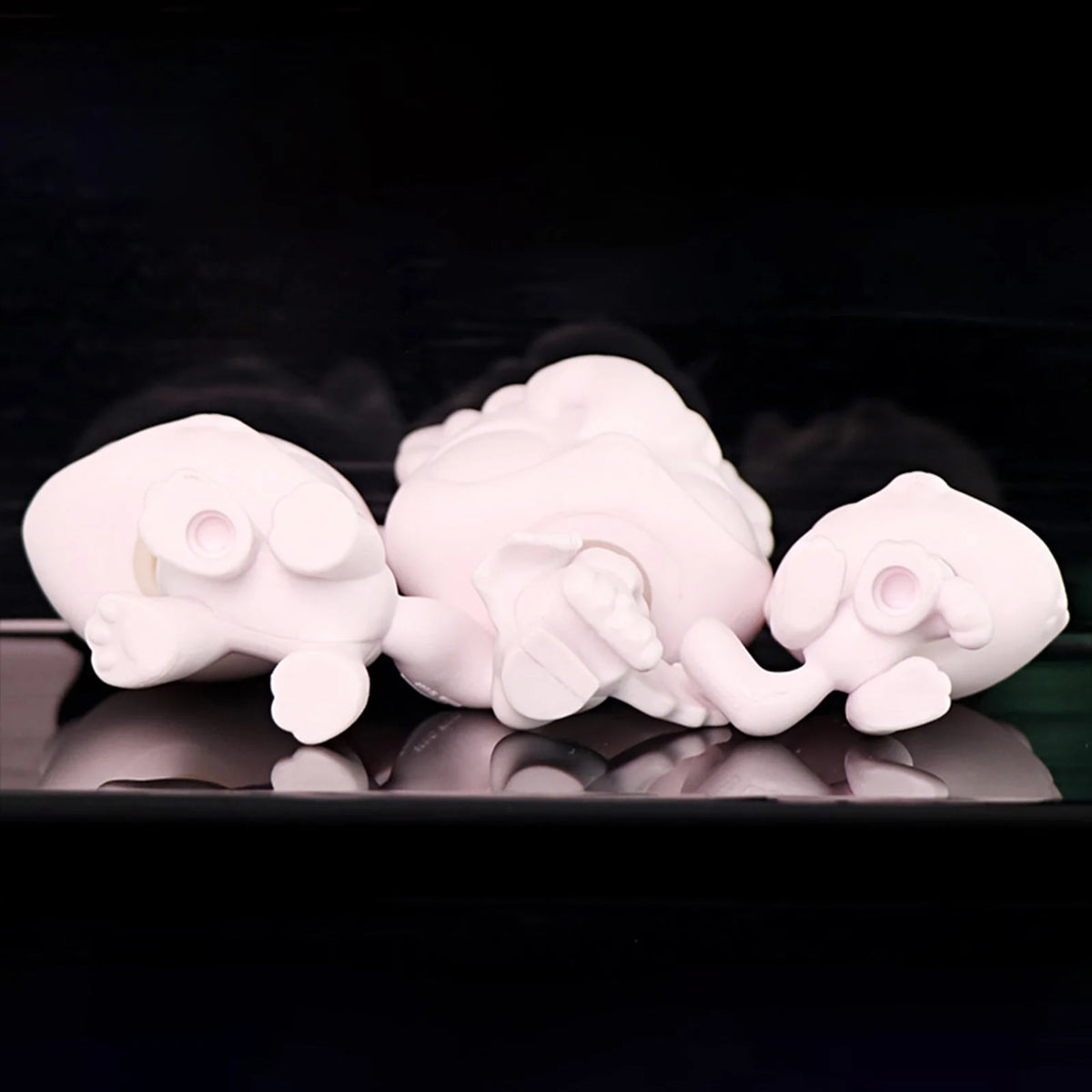 Three white printable bobble head figurines are displayed against a dark background.