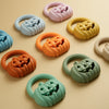 A collection of silicone pumpkin baby teethers in various pastel and orange colors arranged on a light background.