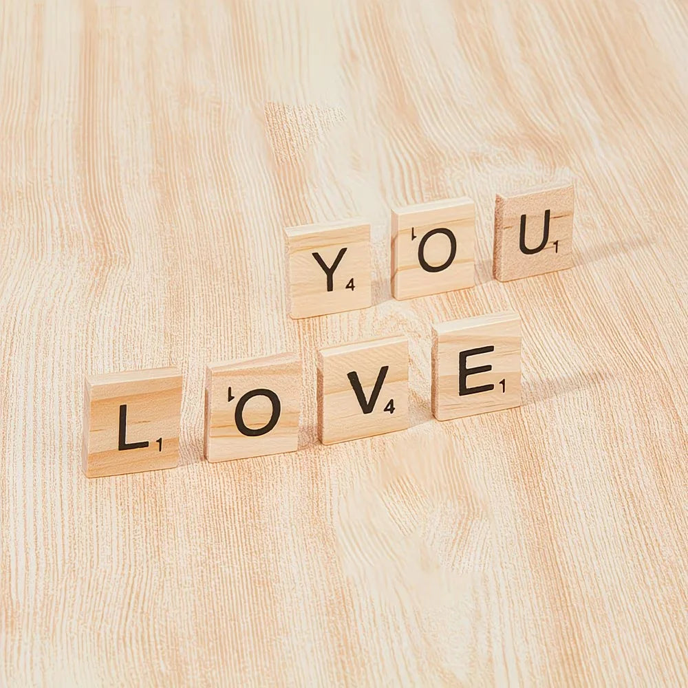 Wooden alphabet letter tiles spelling YOU LOVE arranged diagonally on a light wooden surface
