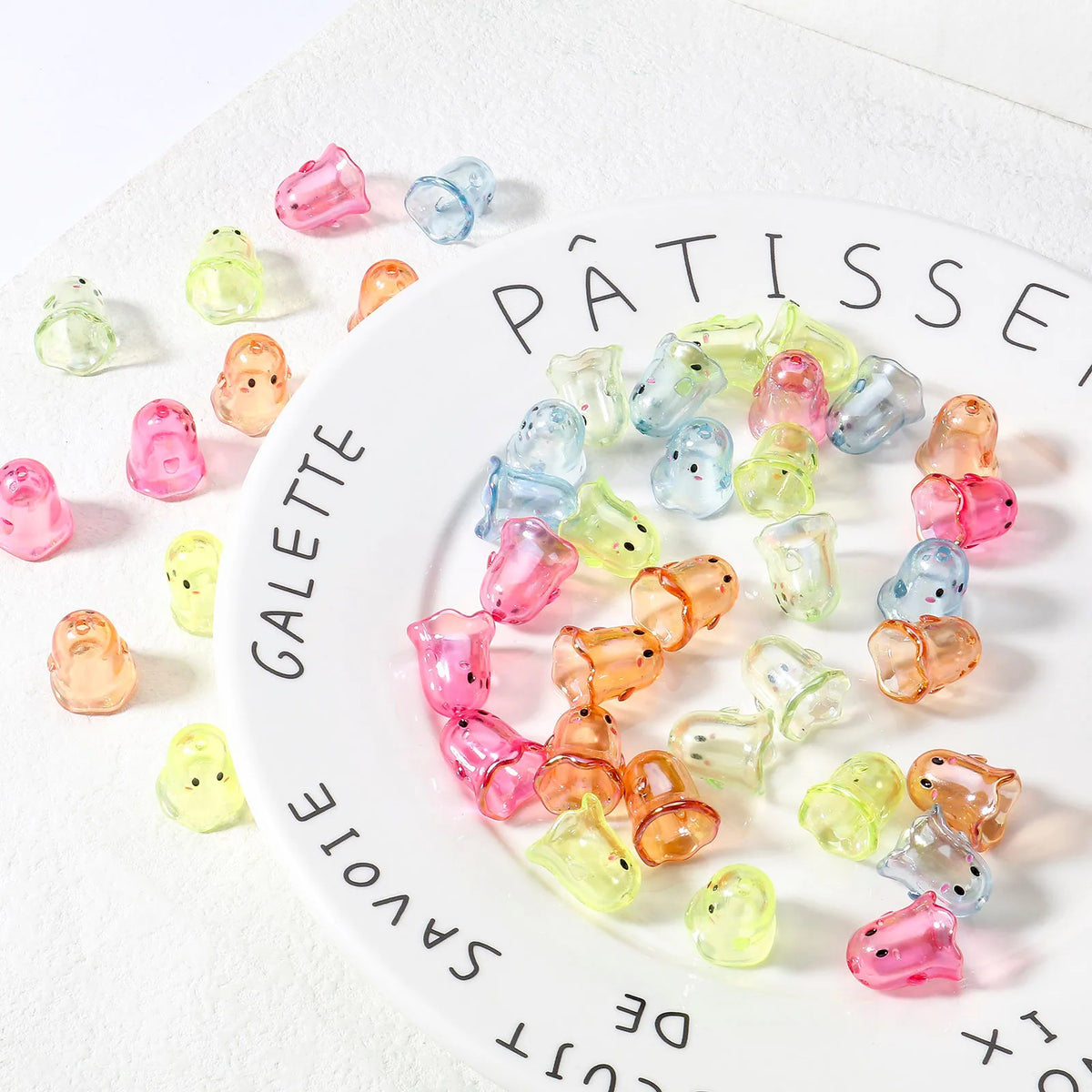 A white plate filled with various colored acrylic ghost beads for jewelry making