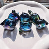 A collection of iridescent blue and green resin cat-shaped molds for keychains, pendants, and pen holders.
