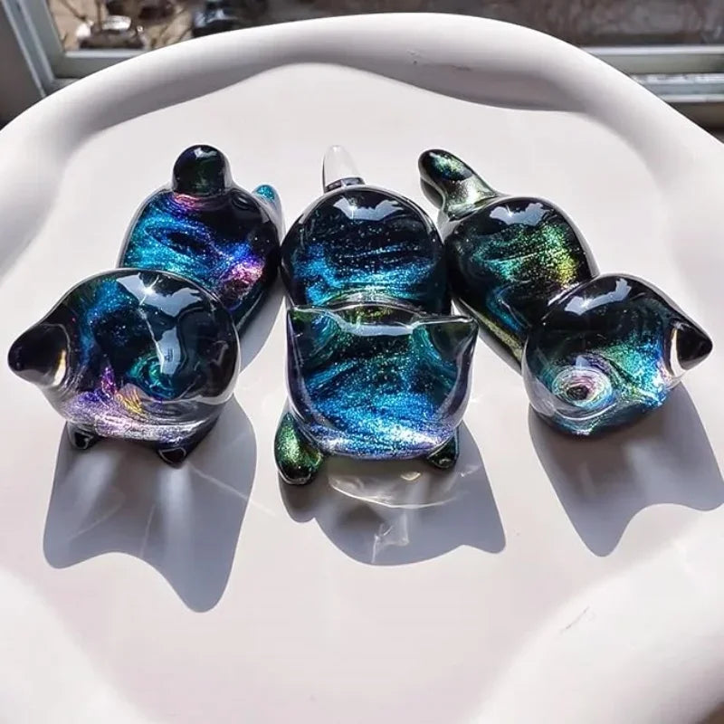 A collection of iridescent blue and green resin cat-shaped molds for keychains, pendants, and pen holders.