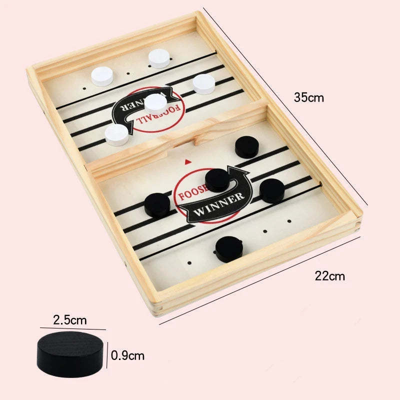 A wooden catapult tabletop hockey game board with black and white pieces and scoring lines.