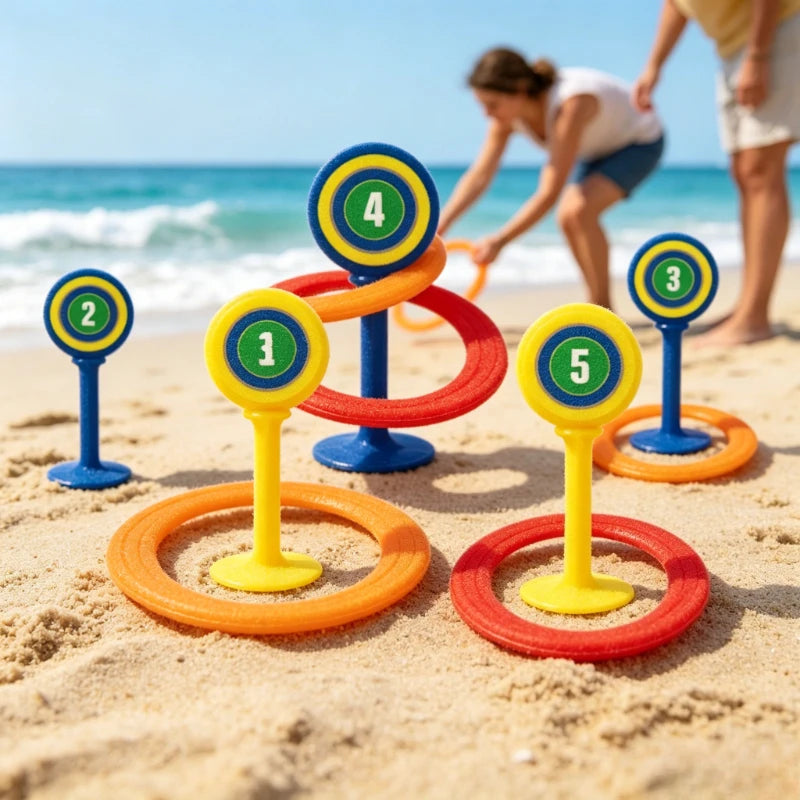 A classic ring toss game set with five numbered rings and stakes is set up on a sandy beach near the ocean.