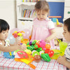 A young child is playing with a pretend play kitchen set featuring colorful fruits and vegetables.