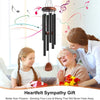 A woman gently touches the forehead of an elderly woman while a decorative wind chime hangs above them.