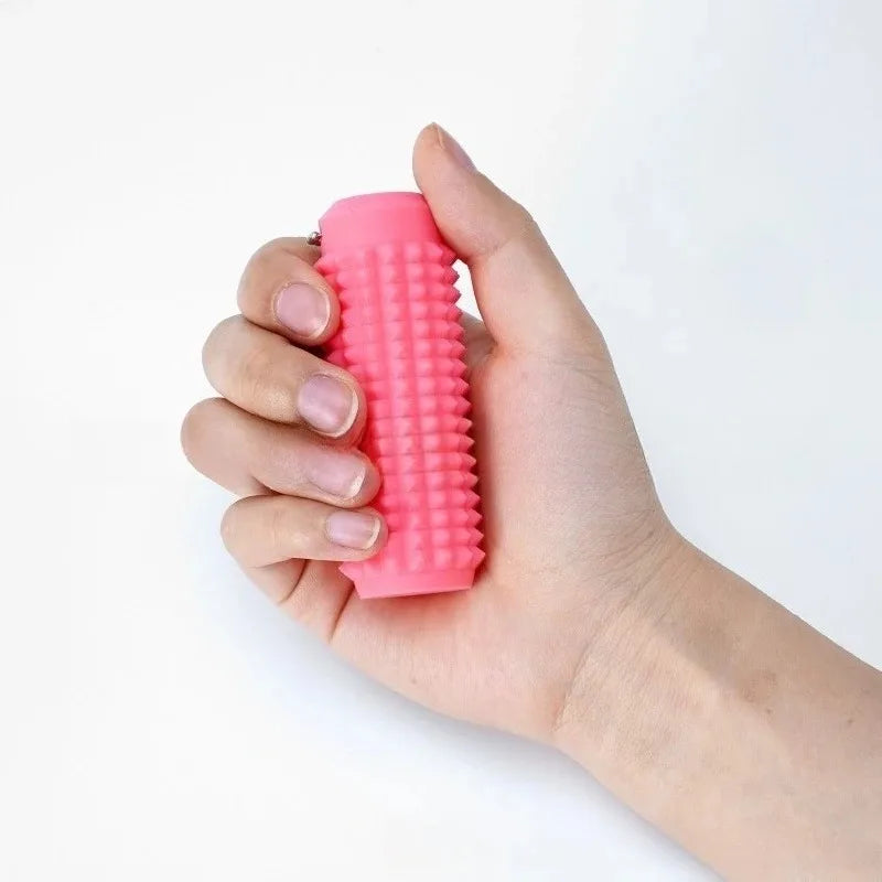 A hand is holding a bright pink spiky sensory keychain for anxiety relief.