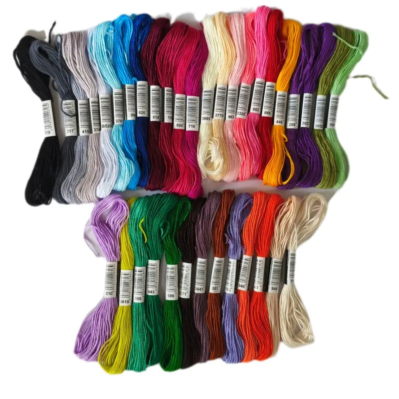 A collection of multicolor embroidery floss skeins in various shades including black, blue, pink, green, and yellow.