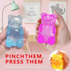 A hand holds a pink gummy bear sensory stress relief fidget toy next to a white sign titled My Daily Melody.