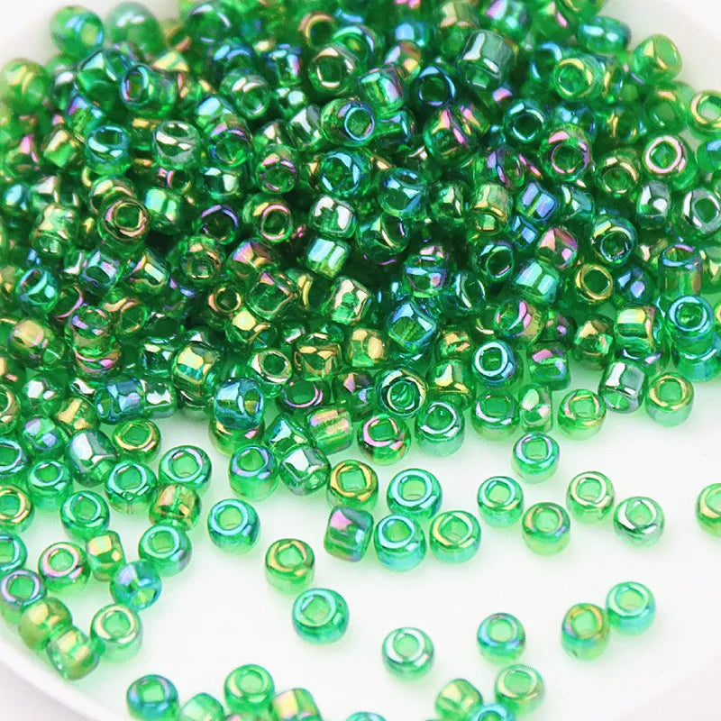A pile of small, vibrant green glass rice beads for DIY jewelry and crafting.