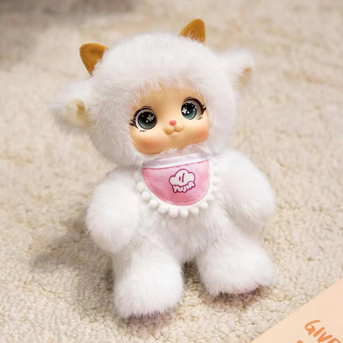 A white plush toy resembling a rabbit with brown ears and pink accents, sitting on a light-colored surface.