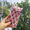 A hand holds a pink fabric storage bag featuring repeating designs of Miffy rabbits and strawberries.