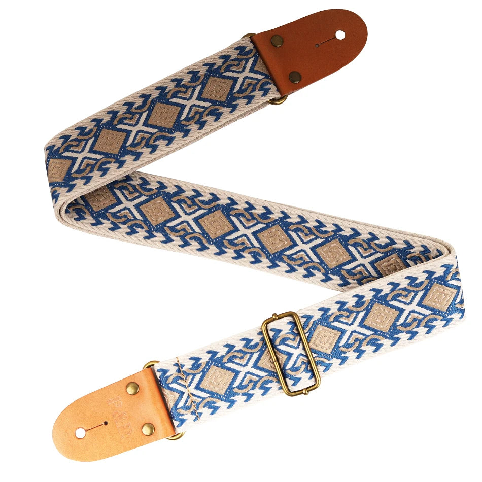 A beige and blue embroidered guitar strap with leather ends shown in a diagonal layout.