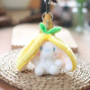 A cute white bunny plush toy with yellow fabric ears and a yellow cloth covering, resting on a woven mat.