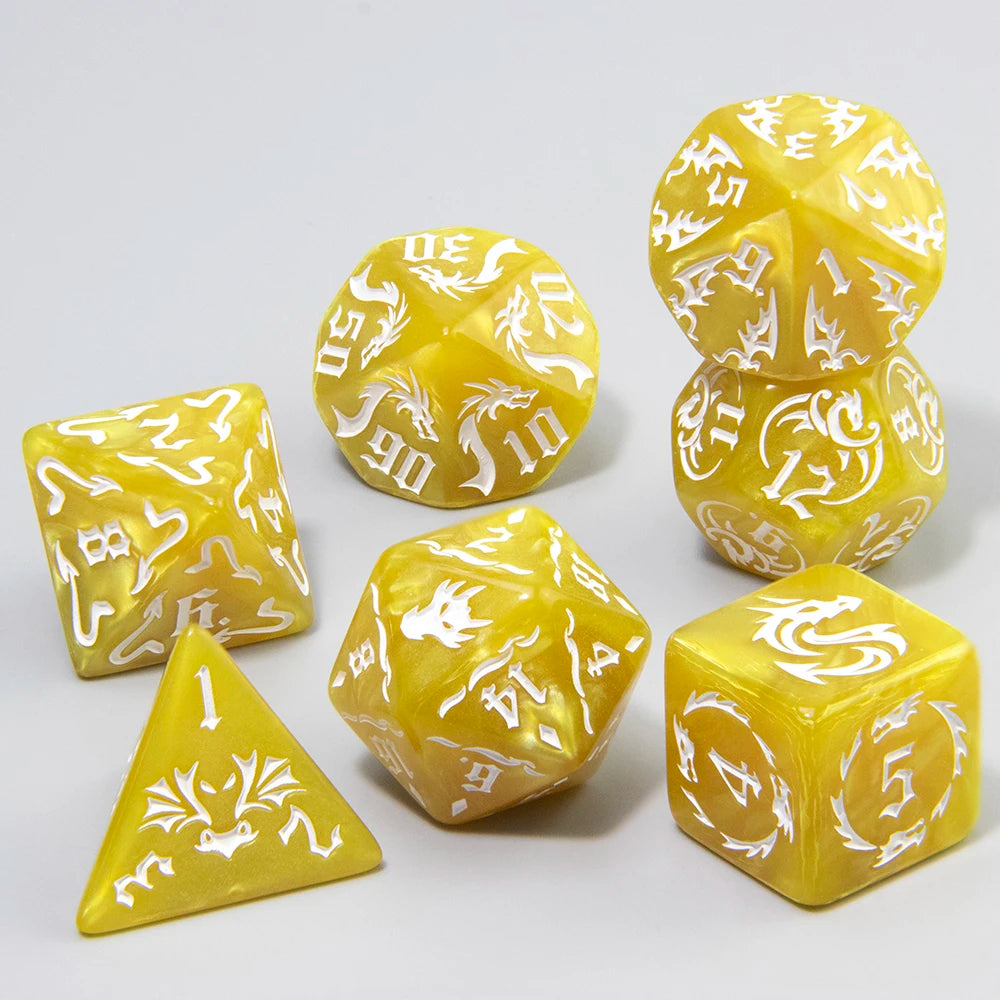 A set of yellow marble dragon pattern polyhedral dice including a tetrahedron and several other shapes.