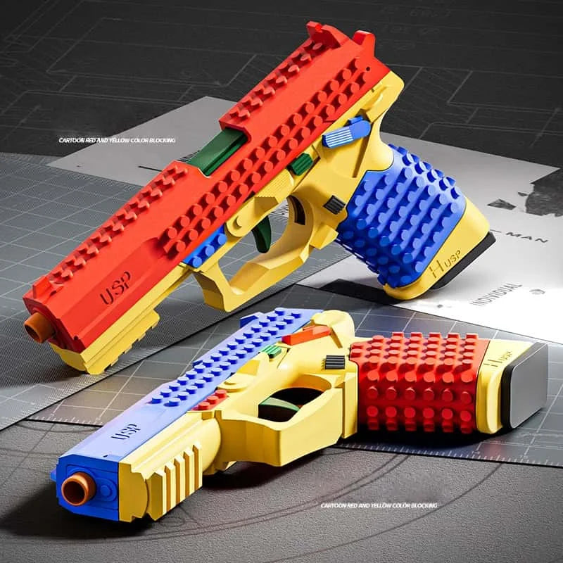 A yellow and red soft-fire gel blaster pistol toy gun is shown in a tactical firing pose on a dark surface.