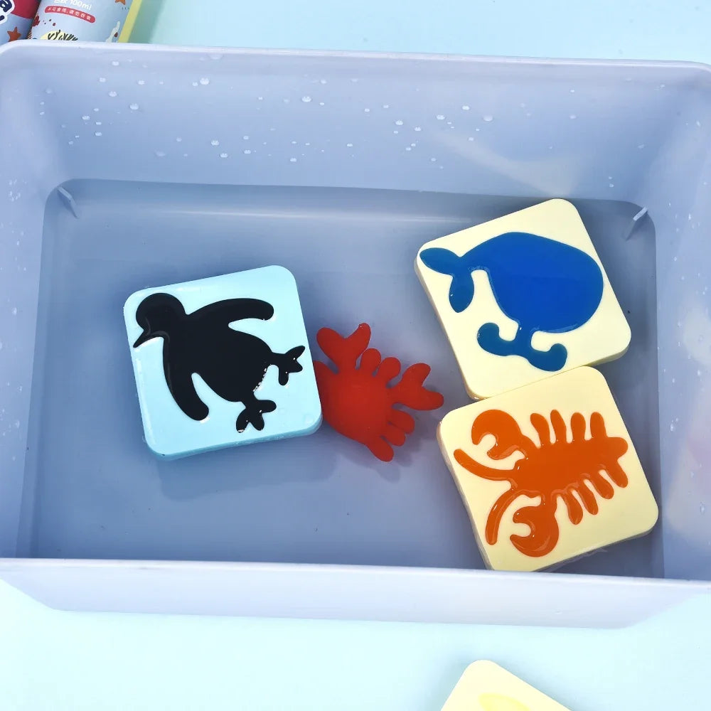 A craft kit containing three plastic figures: a black duck, a blue duck, and an orange crab, set in a light purple tray.