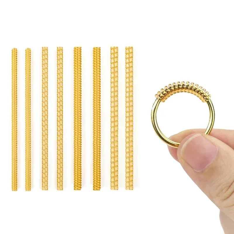 A set of ten gold-colored ring size adjusters arranged in a row, shown next to a hand holding one adjuster.