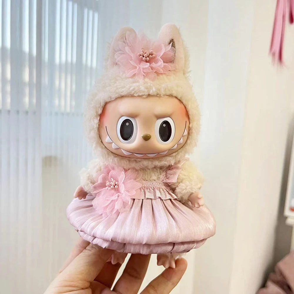 A small doll wearing a pink wedding dress outfit set with fluffy hair and floral accents.