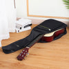 A black padded water-resistant guitar bag is shown open, containing a reddish-brown acoustic guitar.