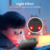 A child is interacting with a gray hand clapping drum toy that emits a light effect.