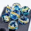 A set of resin dice featuring golden elven numbers on blue and clear translucent dice.