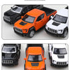 Three die-cast metal F150 off-road pickup trucks in black, orange, and white colors shown from different angles.