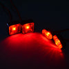 Two bright red LED warning lights illuminate a dark surface, casting beams of light.