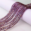 A close-up of purple and pink faceted glass crystal beads strung together for jewelry making.