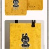 A yellow paper bag featuring a black cartoon monster face and the text Monsters by Monsters.