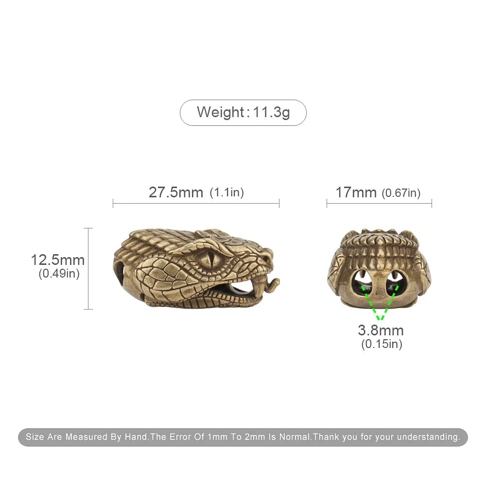A brass snake head bead for a paracord lanyard, showing its size and detail.