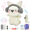 A handmade white and gray kitten crochet toy with a knitted hat, along with yarn and tools for crafting.