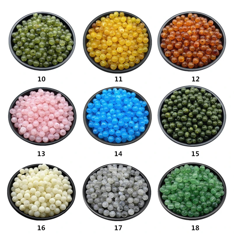 A collection of eighteen bowls filled with various colors of acrylic round beads for jewelry making.