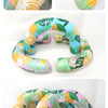 A colorful U-shaped inflatable swim ring with leaf and citrus patterns, shown in various close-up angles.